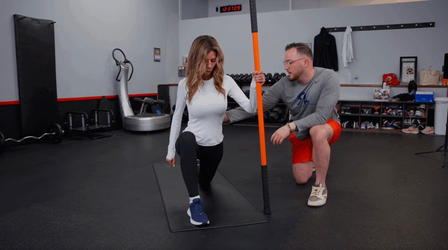 A Rehab Lab clinician coaching an athlete through a split-squat assessment in the clinic rehab gym