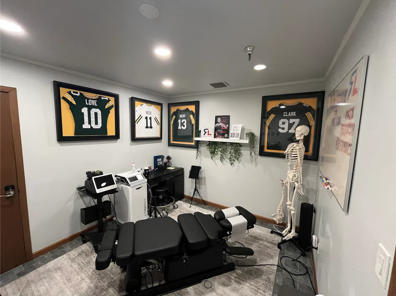 Framed pro athlete jerseys on the wall of the Rehab Lab treatment room