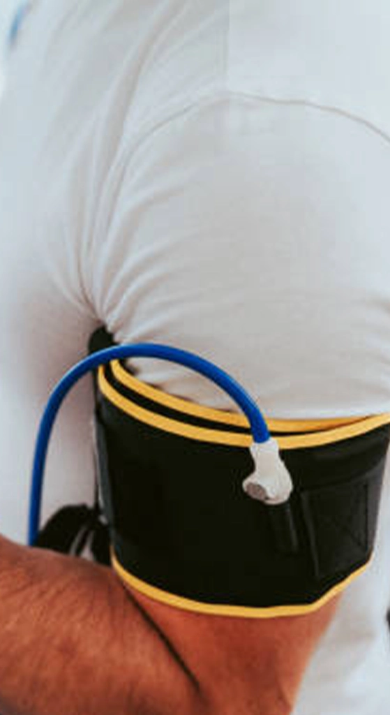 Close-up of a blood flow restriction cuff secured around a person’s upper arm during training or rehabilitation.