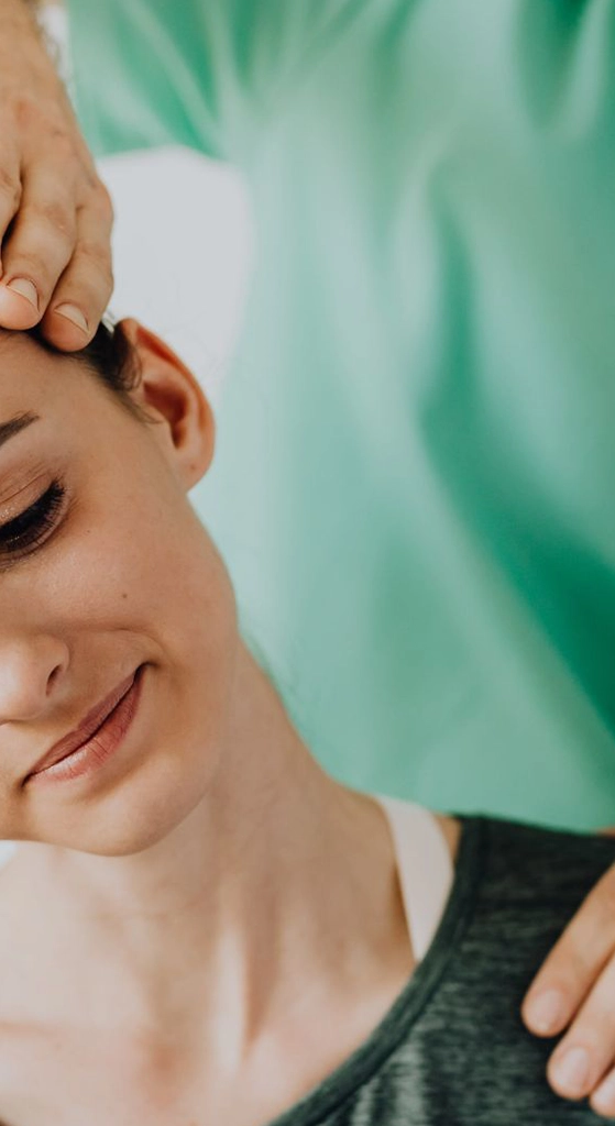 Provider guiding a gentle neck treatment for a patient during a chronic pain relief session.